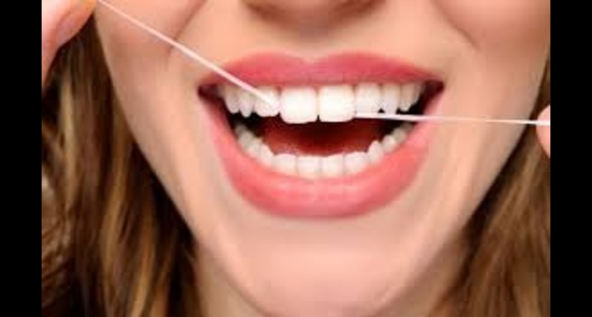 Person flossing teeth with dental veneers